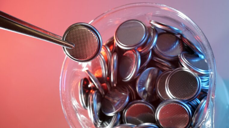 A jar containing button cell batteries.